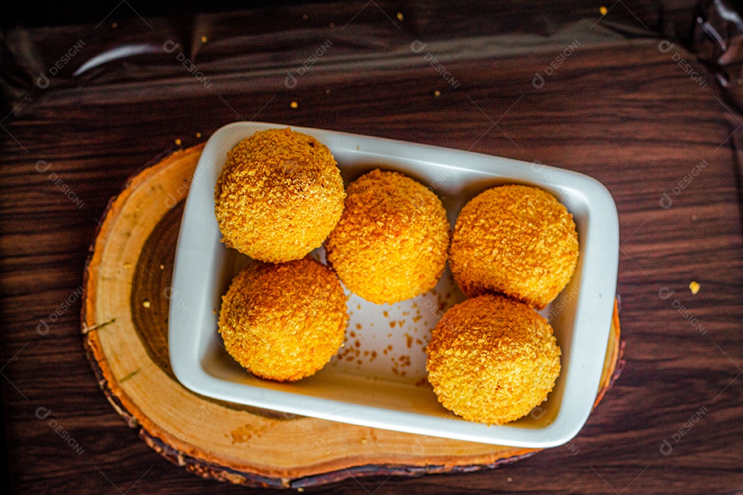 Imagem de coxinhas sobre taboa de madeira.