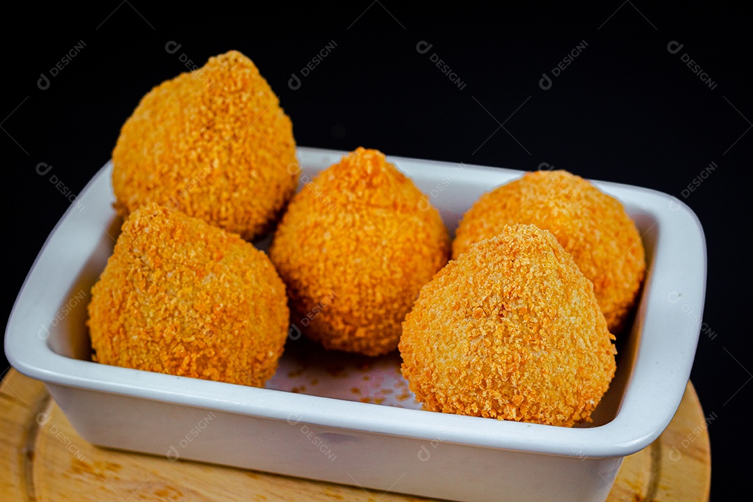 Imagem de coxinhas sobre taboa de madeira.