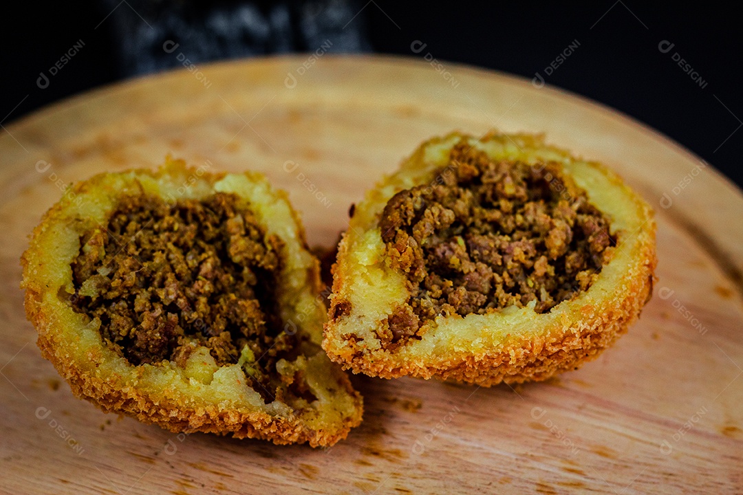 Imagem de coxinhas sobre taboa de madeira.