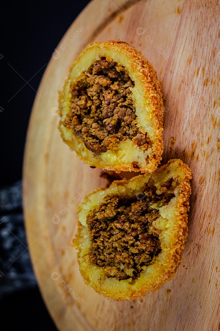 Imagem de coxinhas sobre taboa de madeira.