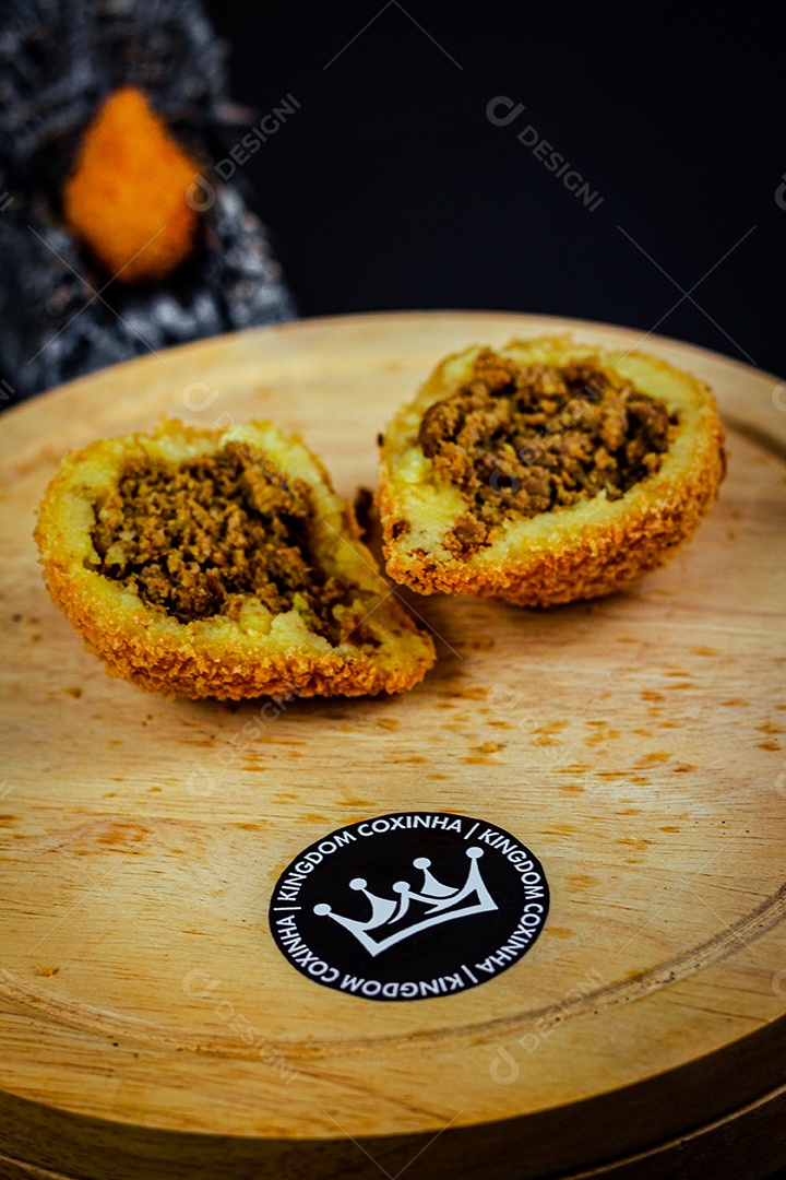 Imagem de coxinhas sobre taboa de madeira.