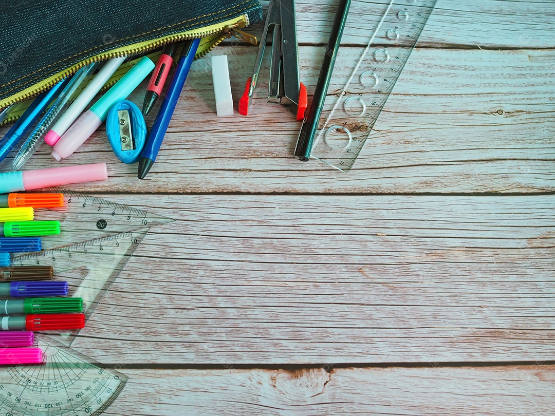 A vista superior de artigos de papelaria em mochilas escolares e lápis organizados.