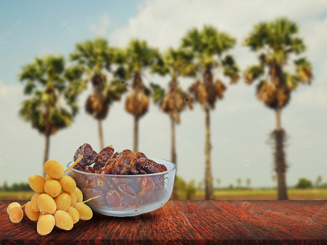 Exibição de tâmaras frescas e secas em uma mesa de madeira com borrão.