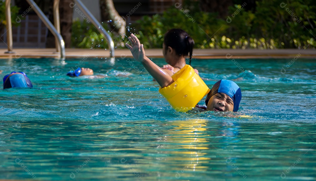 Menino praticando natação na piscina.