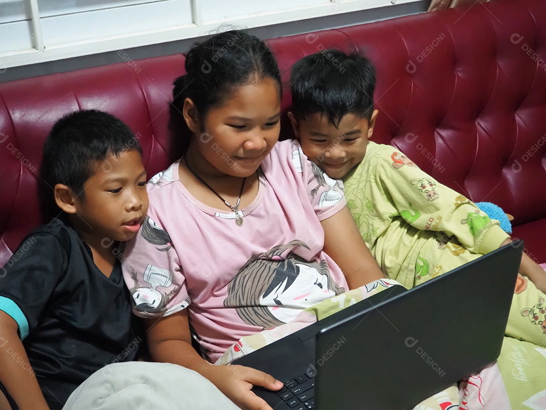 Garoto e garota sentem-se alegremente assistindo a um filme em seu laptop.