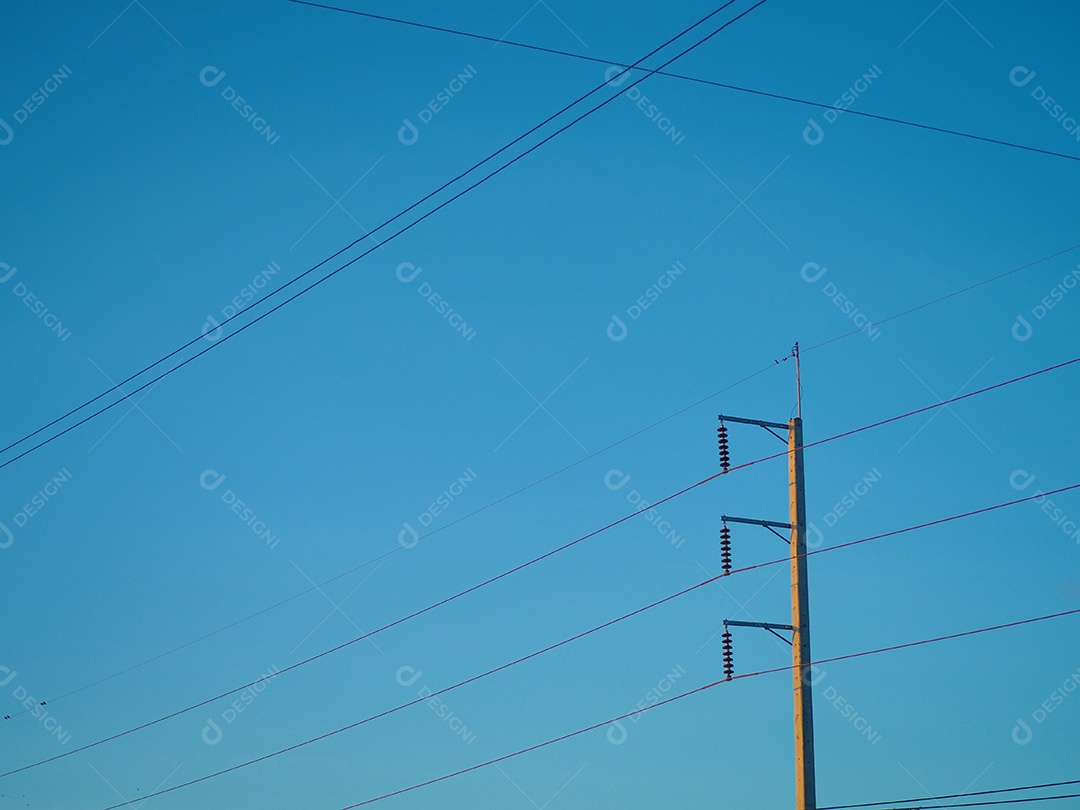 O poste de luz de alta tensão preso a vários fios principais.