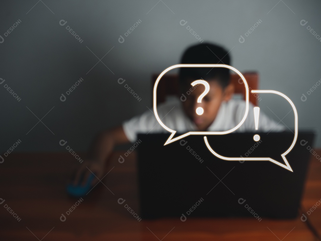 Fotos borradas de menino sentado olhando para o laptop e sua mão.