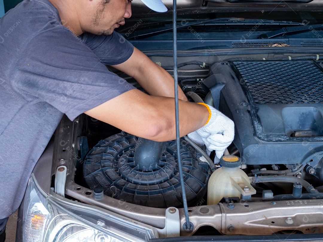 Mecânico segurando uma chave de bloco enquanto conserta um carro.