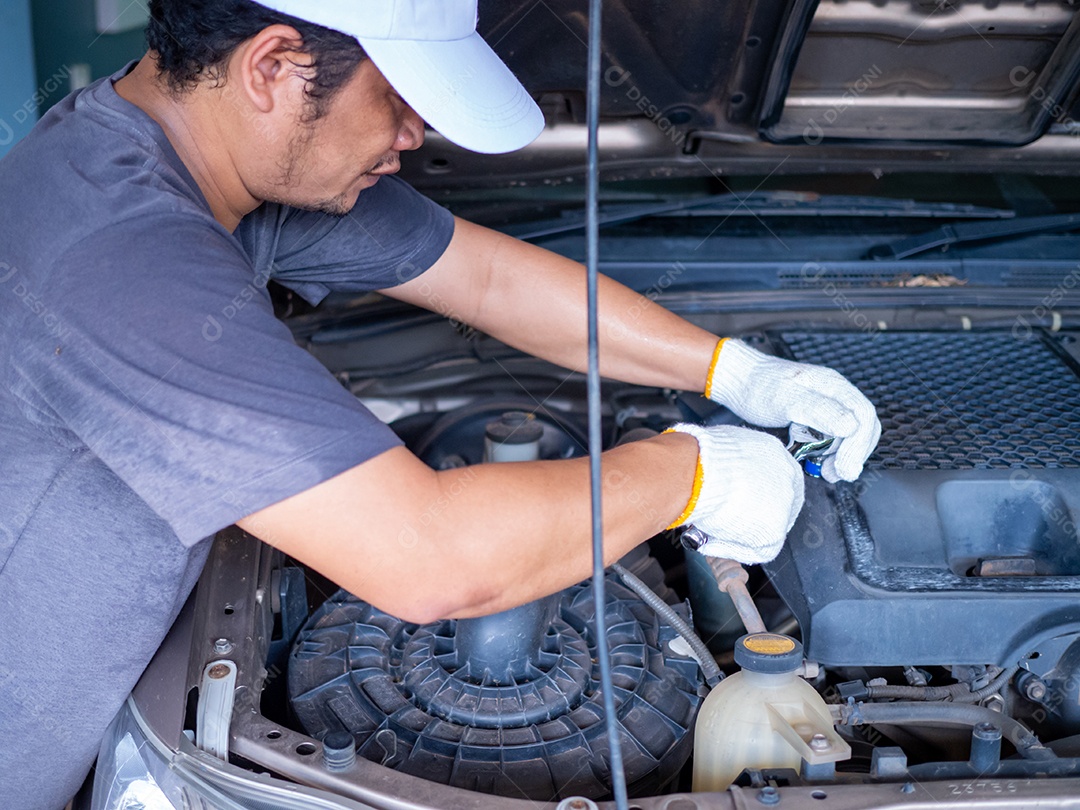 Mechanic holding a block wrench while repairing a car.