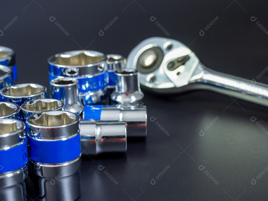 Conjunto de chave de bloco e chave de catraca em um fundo preto.