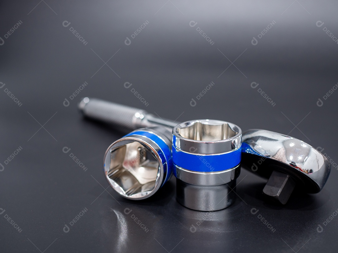 Conjunto de chave de bloco e chave de catraca em um fundo preto.