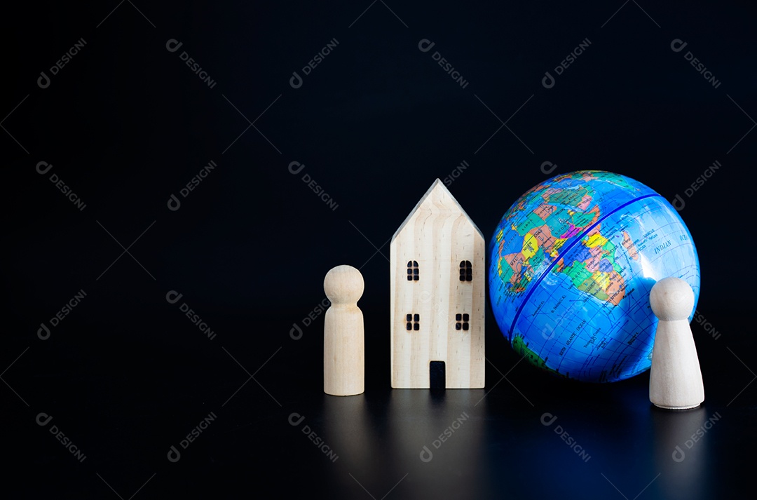 Modele casas de madeira e globos em miniatura em branco sobre um fundo preto.