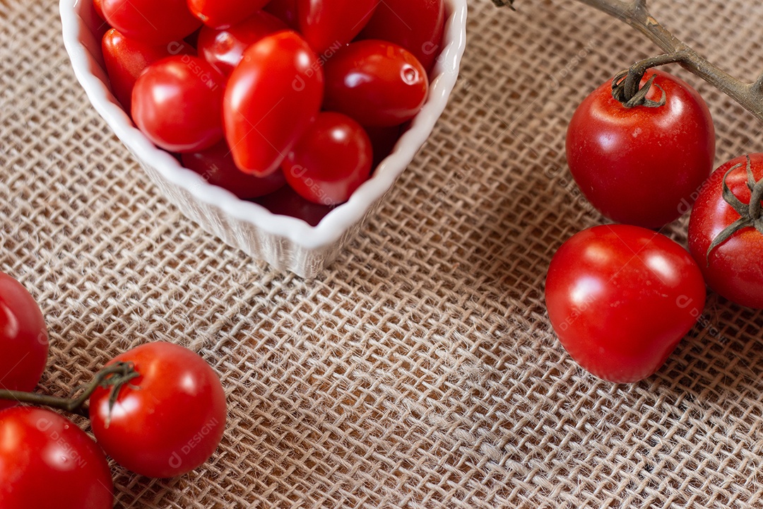 tomates dentro de uma tigela branca e sobre uma mesa de palha