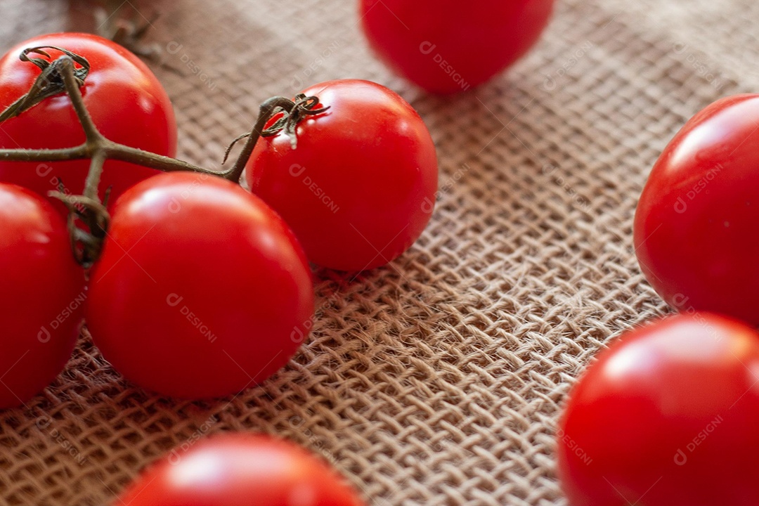 vários tomates pequenos em uma mesa de palha