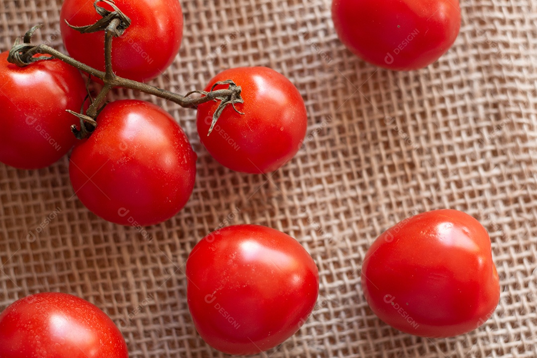 vários tomates pequenos em uma mesa de palha