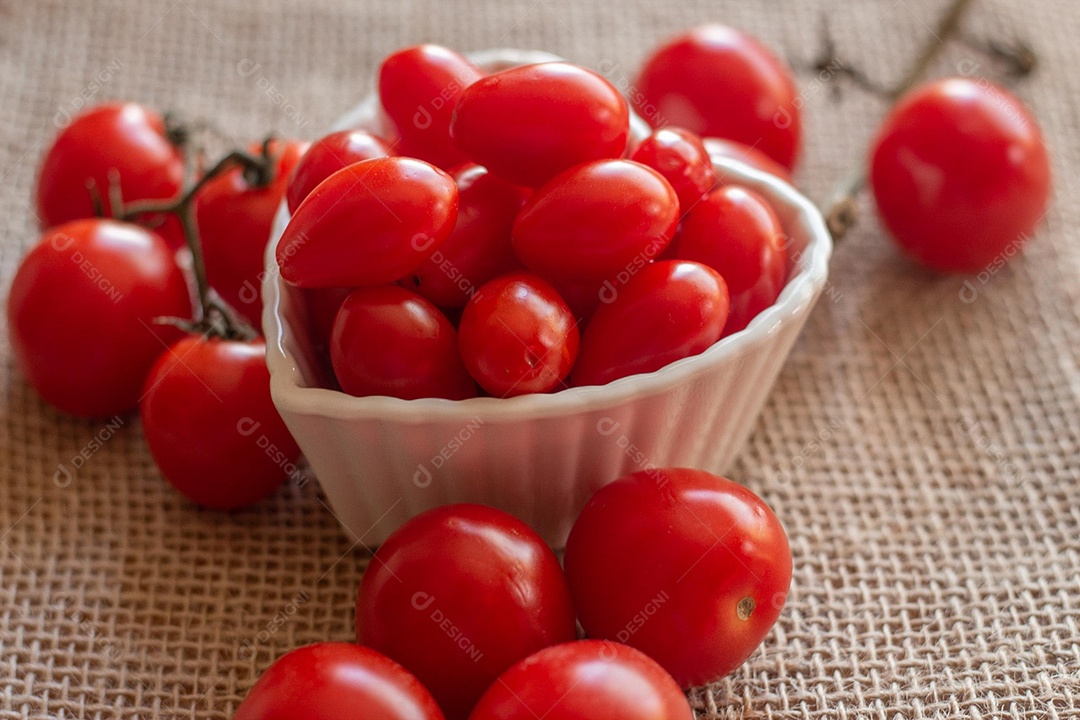 tomates dentro de uma tigela branca e sobre uma mesa de palha