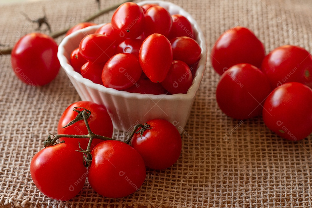 tomates dentro de uma tigela branca e sobre uma mesa de palha