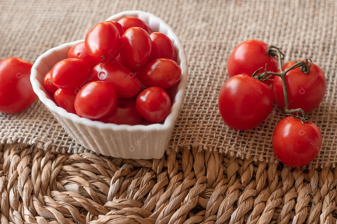 tomates dentro de uma tigela branca e sobre uma mesa de palha