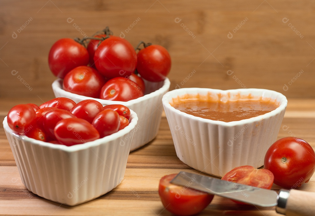 vários tomates pequenos dentro de três tigelas em uma mesa de madeira