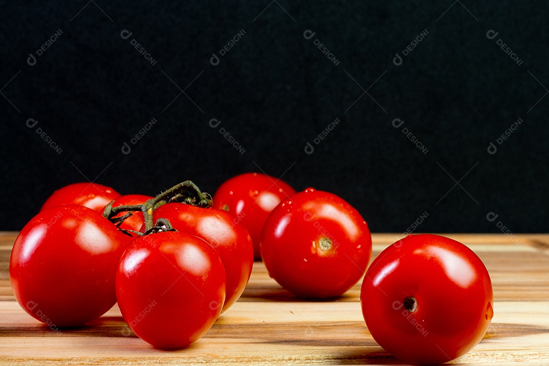 tomates sobre uma mesa de madeira com fundo preto