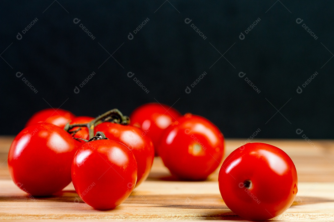 tomates sobre uma mesa de madeira com fundo preto