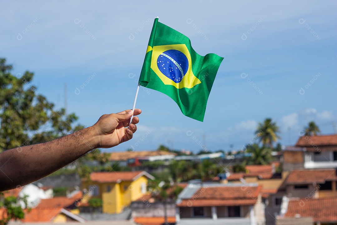 homem segurando uma bandeira brasileira na frente da comunidade