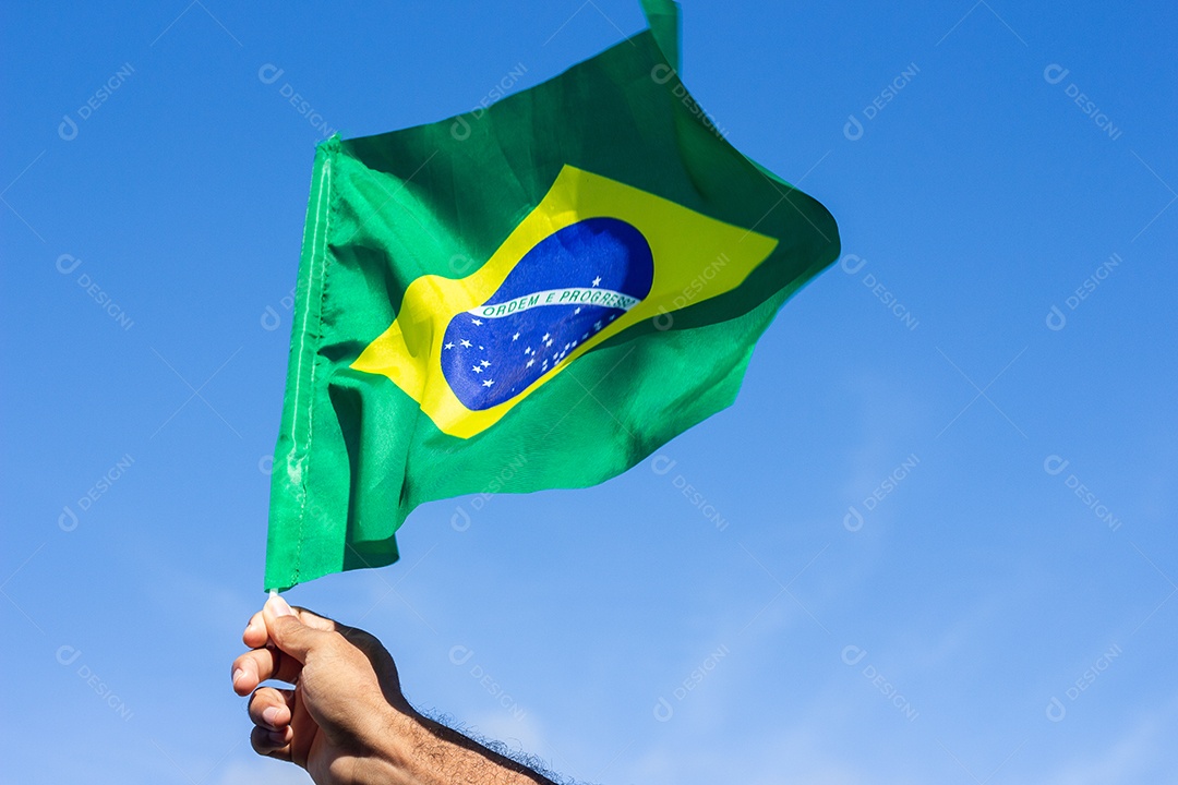homem segurando uma bandeira brasileira na frente da comunidade