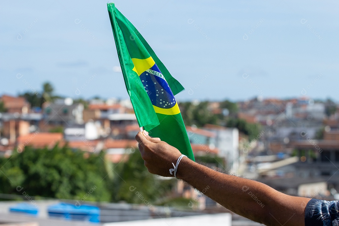 homem segurando uma bandeira brasileira na frente da comunidade