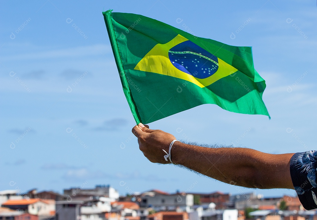 homem segurando uma bandeira brasileira na frente da comunidade