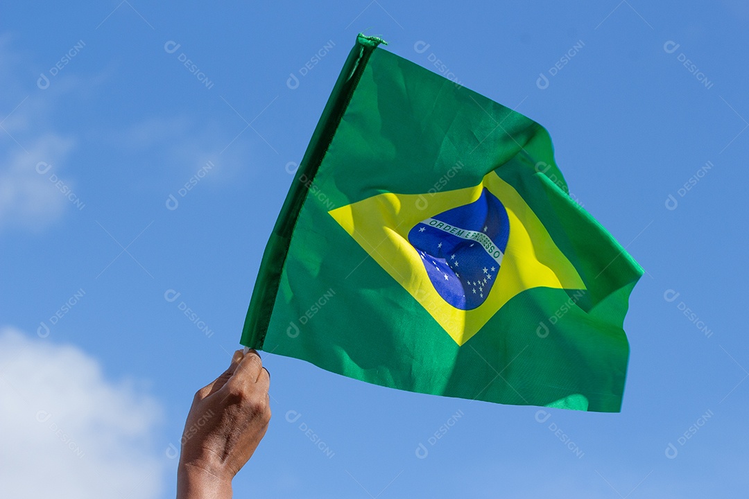 homem segurando uma bandeira brasileira na frente da comunidade