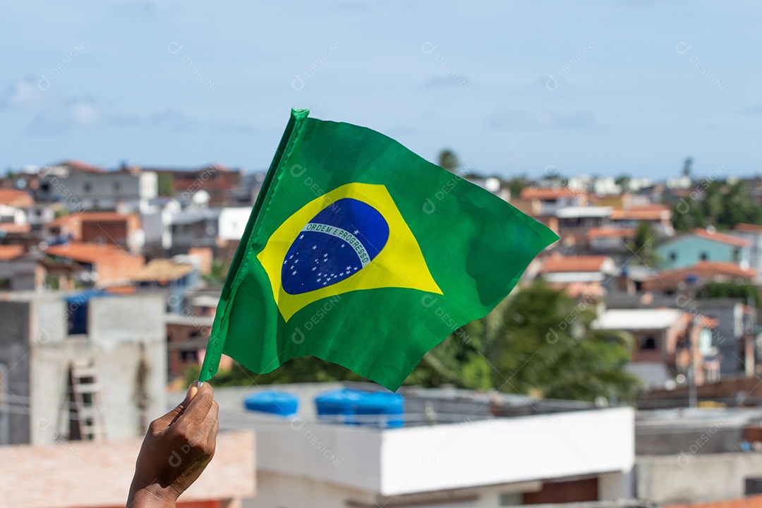 homem segurando uma bandeira brasileira na frente da comunidade