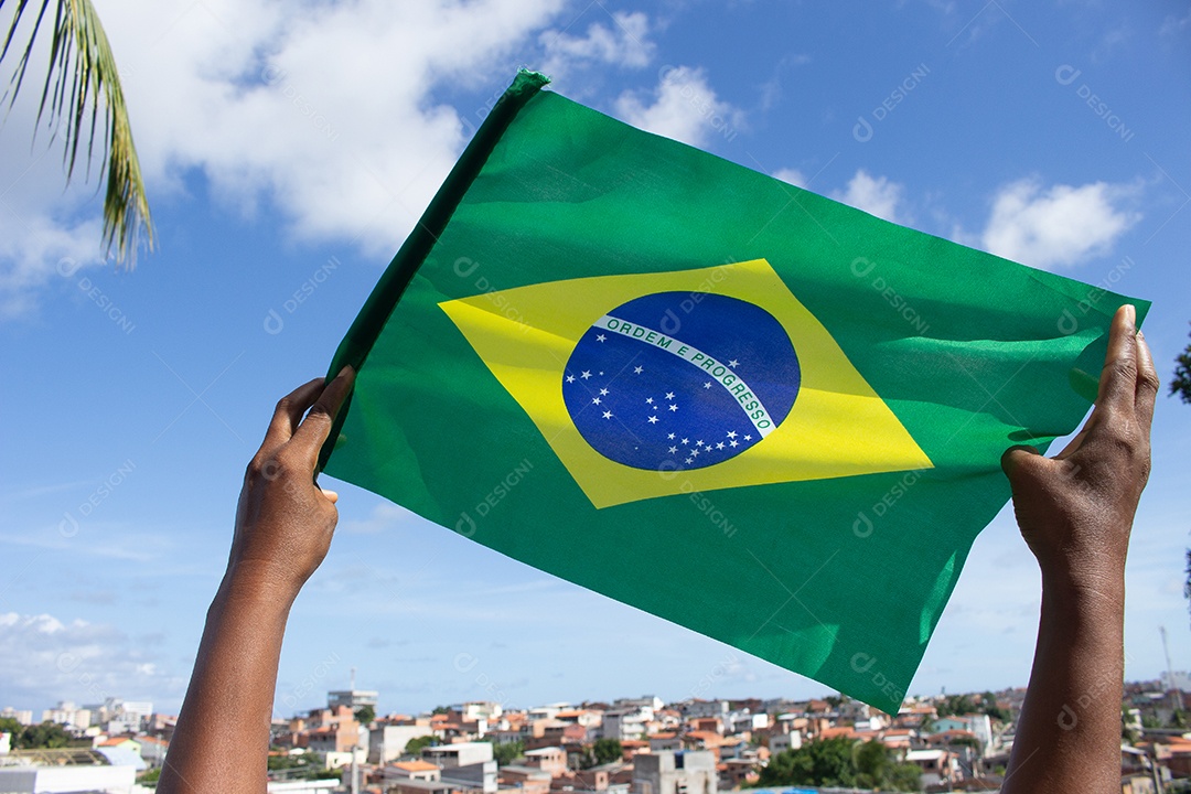 homem segurando uma bandeira brasileira na frente da comunidade