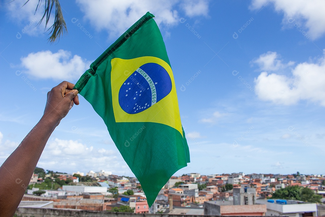 homem segurando uma bandeira brasileira na frente da comunidade