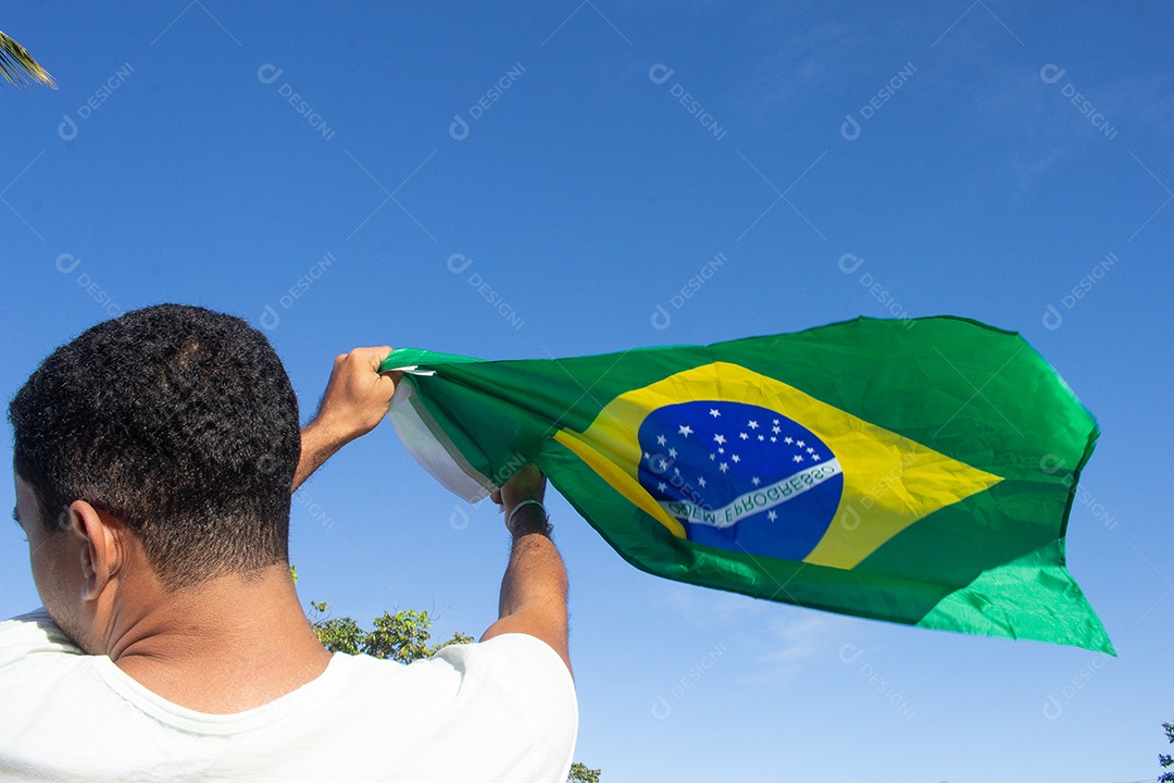 homem segurando a bandeira do brasil em suas mãos