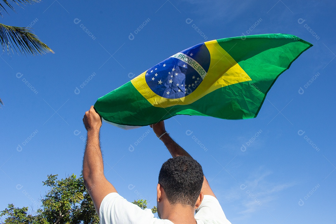 homem segurando a bandeira do brasil em suas mãos