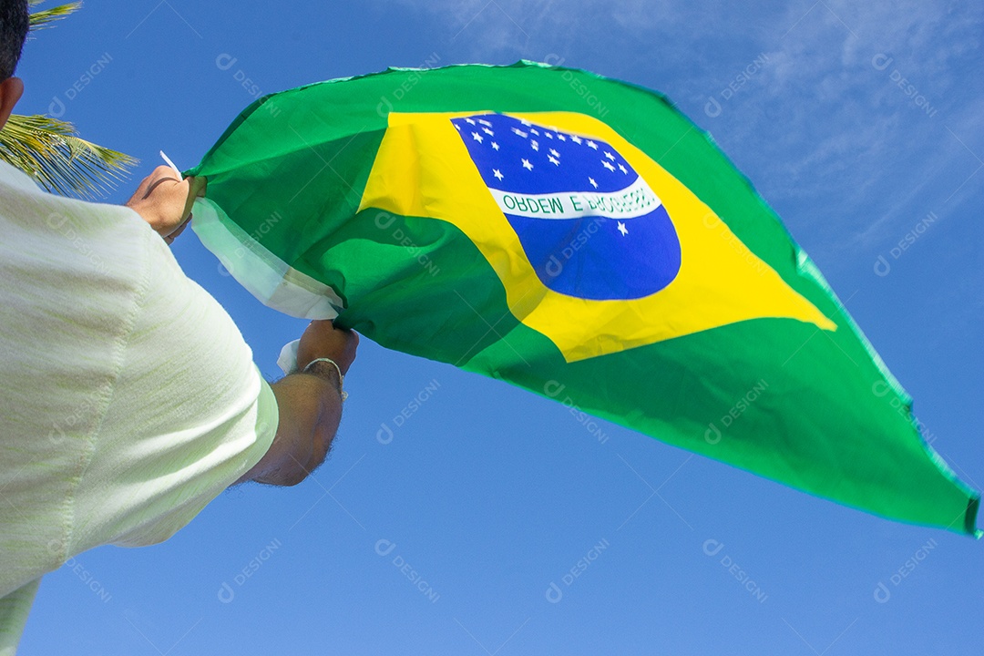 homem segurando a bandeira do brasil em suas mãos