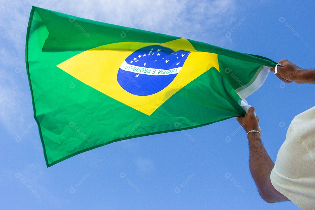 homem segurando a bandeira do brasil em suas mãos