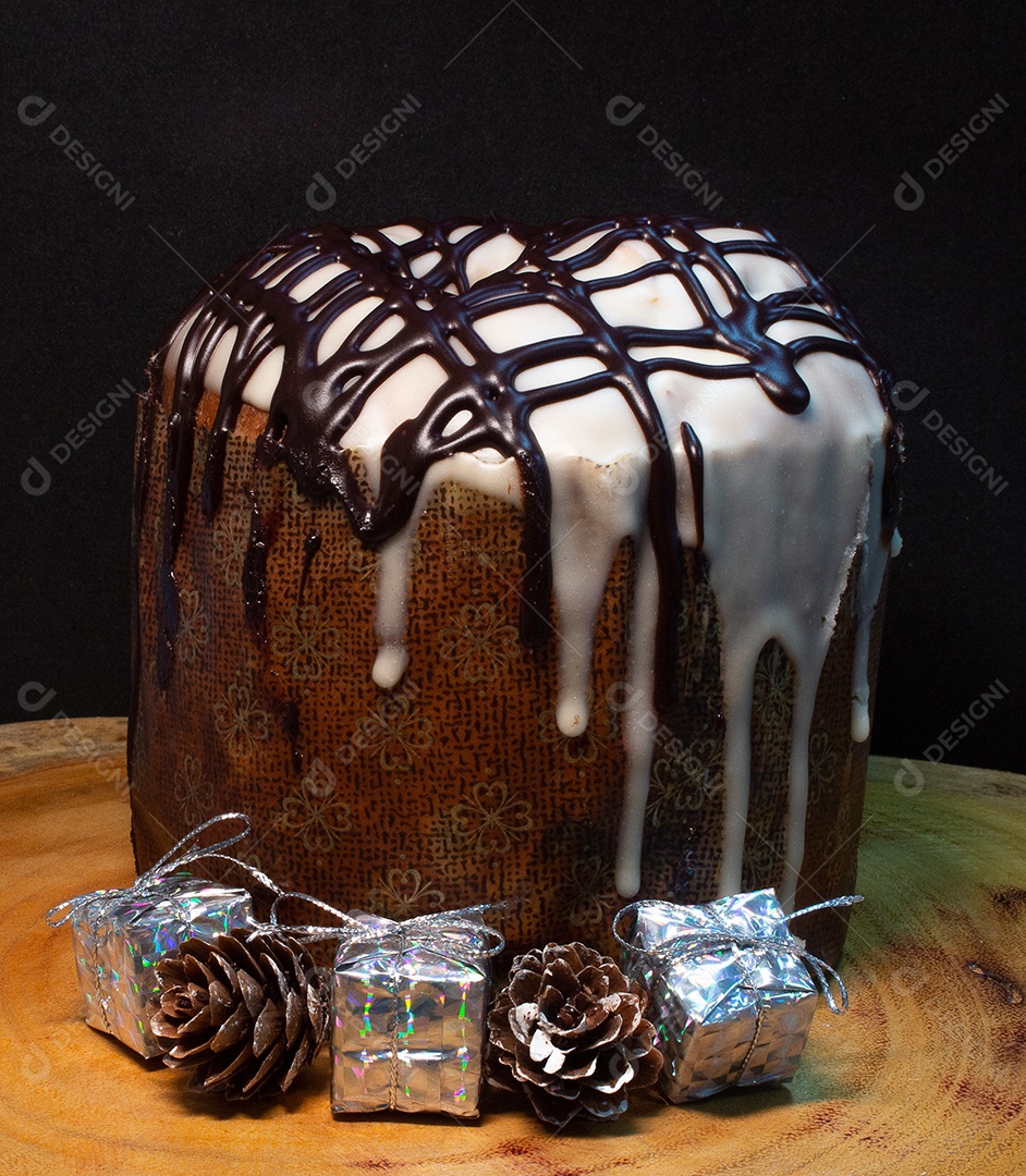 Panetone em uma mesa de madeira com fundo preto cercado