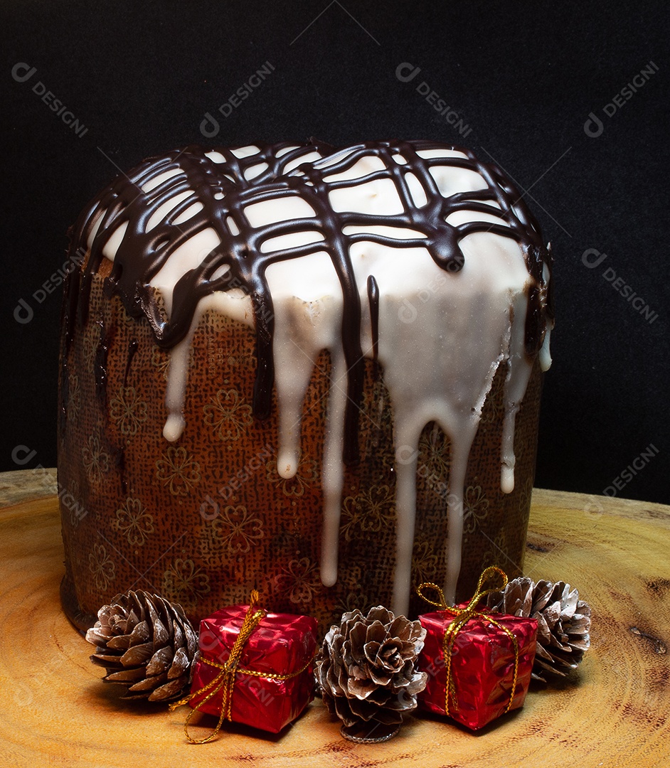 Panetone em uma mesa de madeira com fundo preto cercado