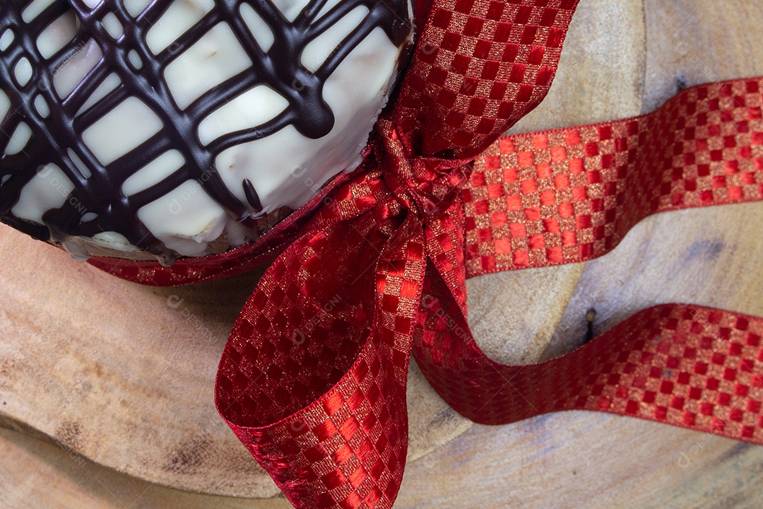 vista superior do panetone sobre uma mesa de madeira com gravata vermelha