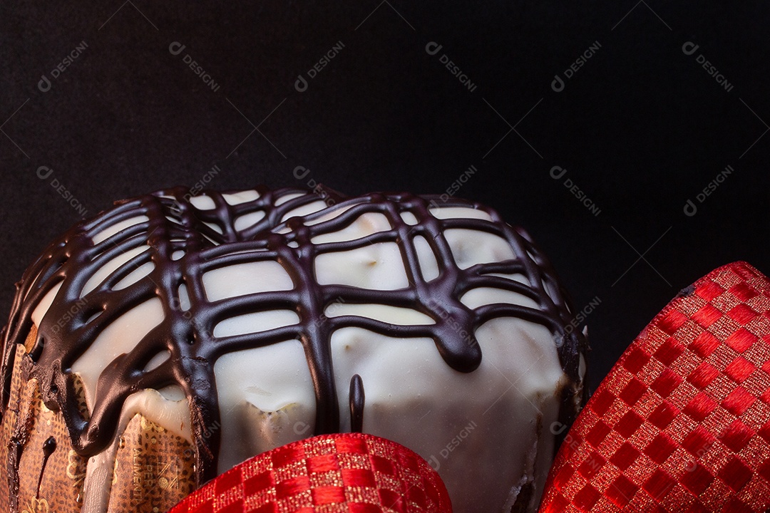 panetone sobre uma mesa de madeira com gravata vermelha com fundo preto