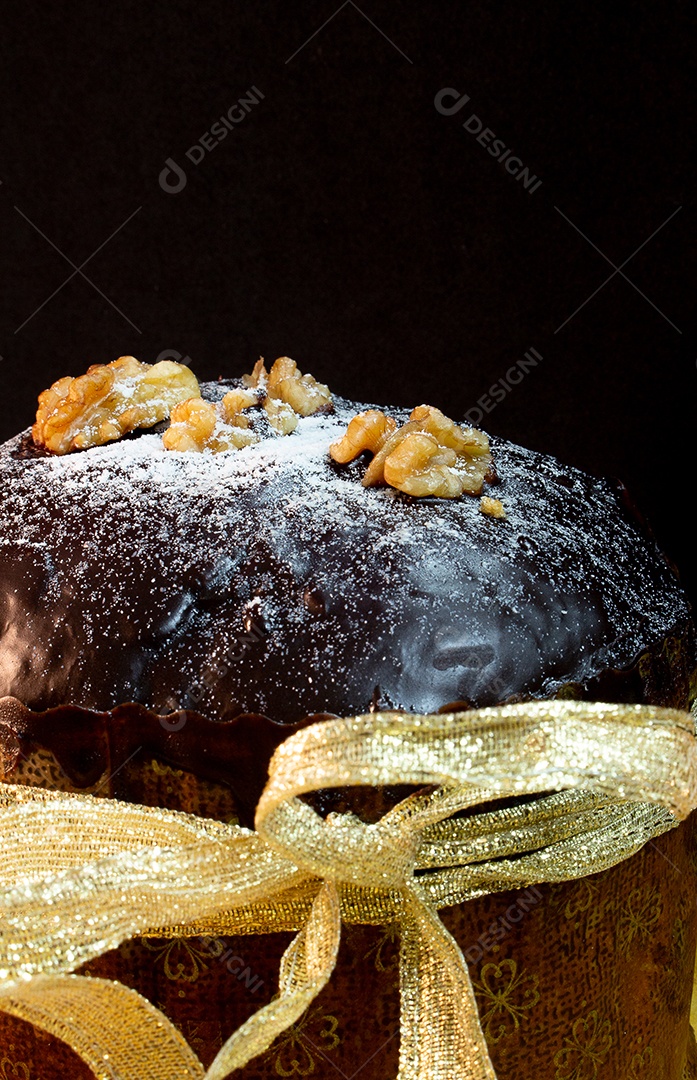 Panetone em uma mesa de madeira com fundo preto cercado