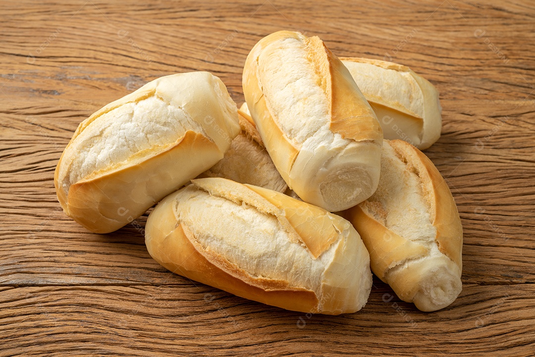 Pão francês, pão de sal ou pistolet sobre a mesa de madeira.