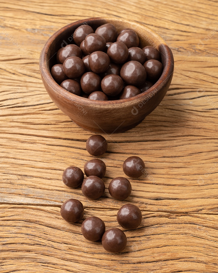Bolas de chocolate maltadas em uma tigela sobre a mesa de madeira.