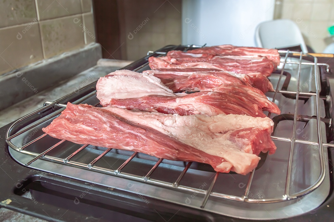 Churrasco em um churrasco elétrico, carnes cruas sendo assadas