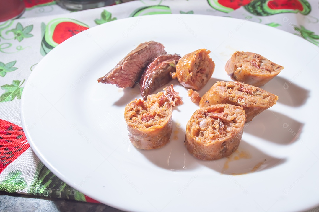 Salsicha assada e fatiada em um prato branco com pequenos pedaços