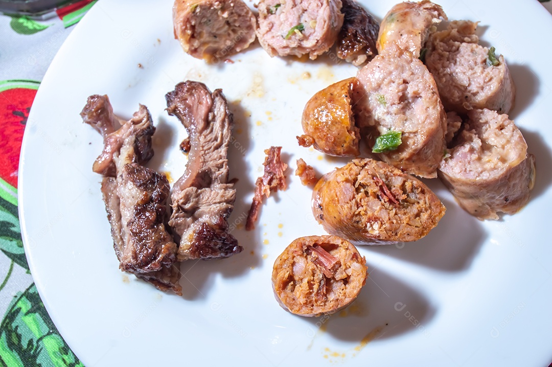 Salsicha assada e fatiada em um prato branco com pequenos pedaços