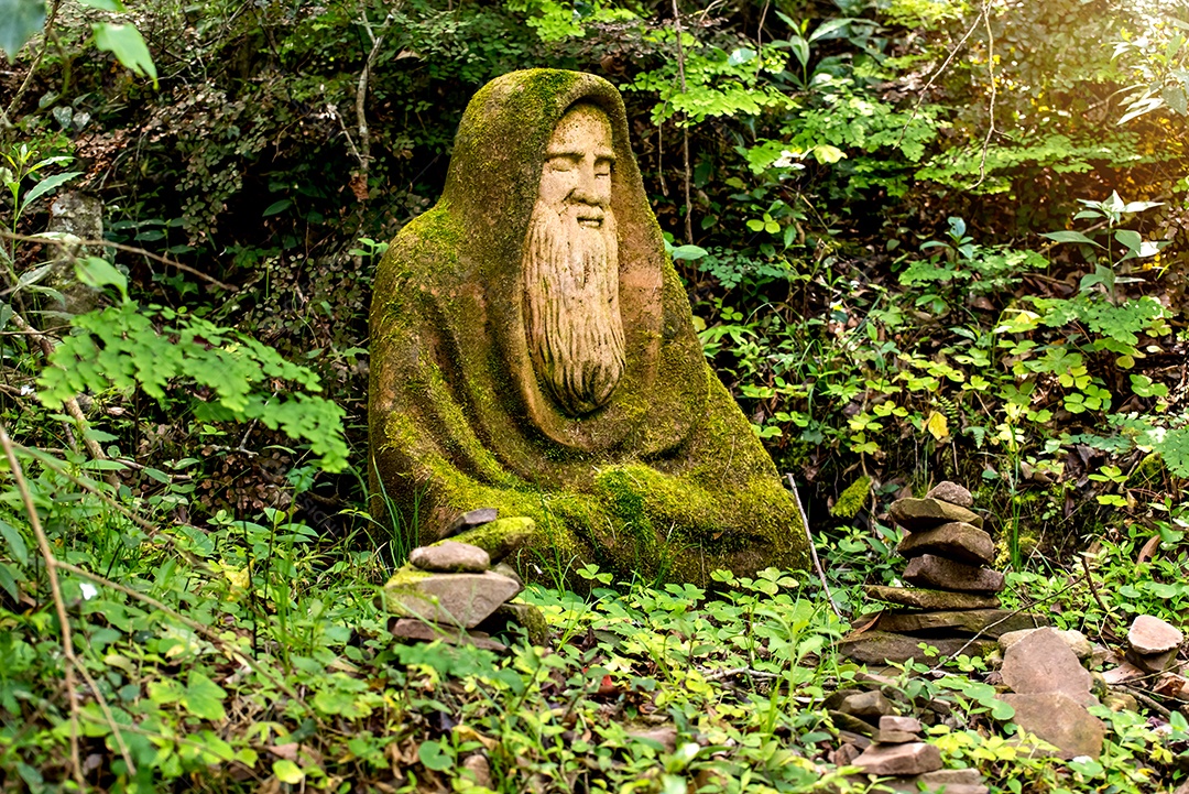 Estátua de um homem barbudo no meio da floresta, escultura