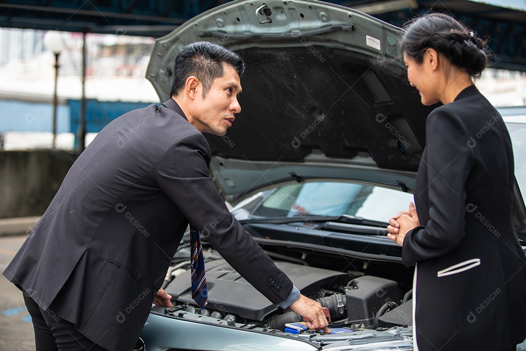 Empresário ajudando a verificar e consertar o carro de uma mulher quebrada