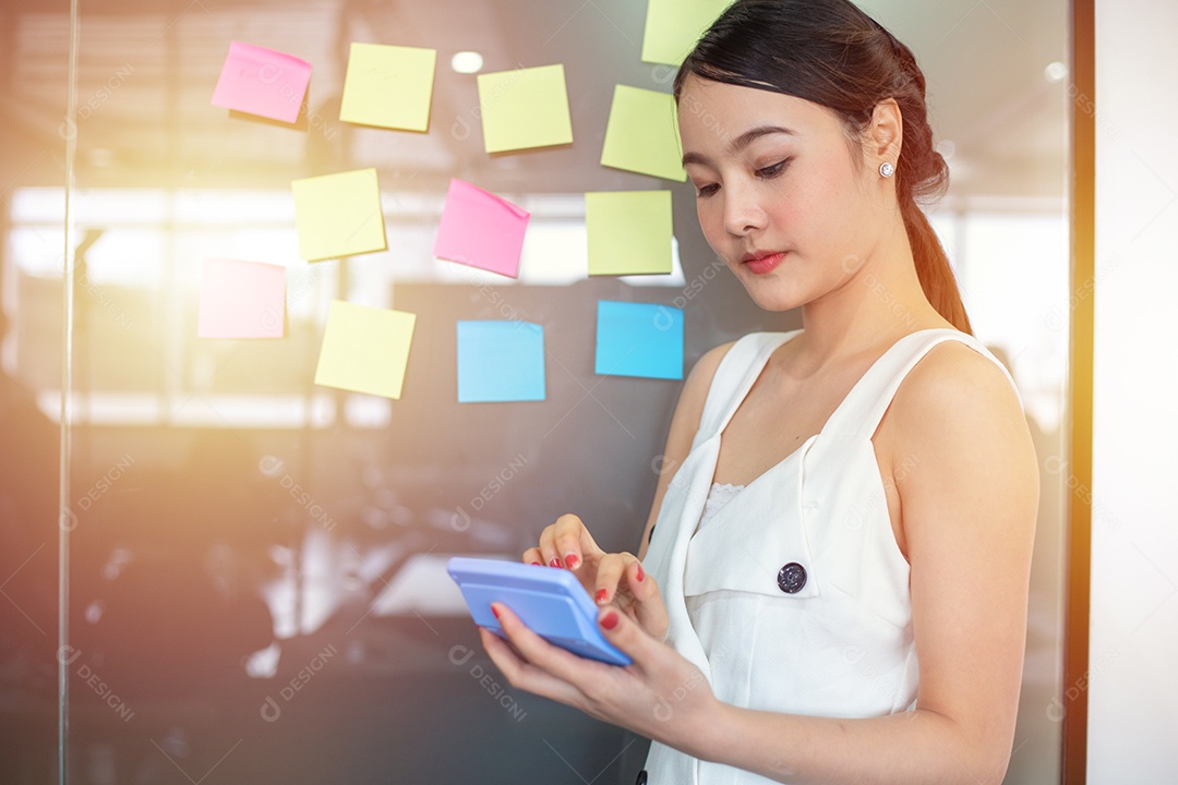 Menina asiática escrevendo roteiro planejando o trabalho de notas adesivas no escritório